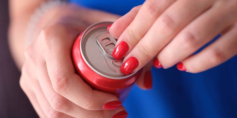 Woman opens can of cold soda closeup. Feeling cool on hot summer day.